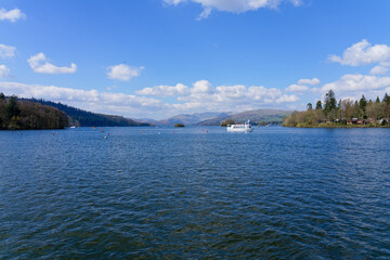Obraz premium Passenger ferries cross Lake Windermere in the spring sunshine.