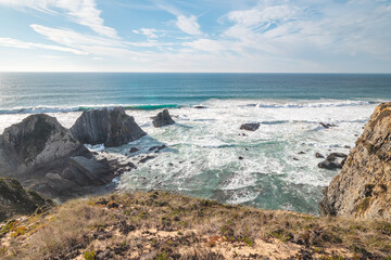 Typical scenery on the Atlantic coast. High rocky cliffs with sandy beaches in Odemira region, western Portugal. Wandering along the Fisherman Trail, Rota Vicentina