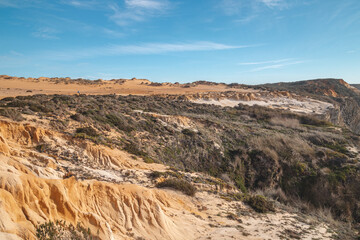 Fototapeta na wymiar Lunar, dry landscape with crumbling limestone and sandy surface in the Odemira region, western Portugal. Wandering along the Fisherman Trail, Rota Vicentina