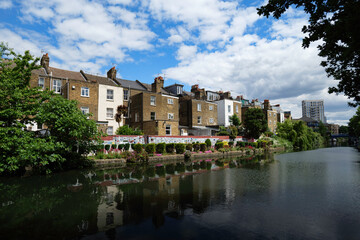 Fototapeta premium London - 05 21 2022: Houses with flower gardens on the Grand Union Canal opposite Meanwhile Skate Park