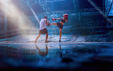Female kickboxing training with male trainer gives self-defense classes to female fighter at GYM....