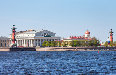 Naklejka premium Saint Petersburg on sunny May day. View from Neva River to Strelka of Vasilyevsky Island with red Rostral columns and Stock Exchange building. Beautiful cityscape. Spring travel and city walks