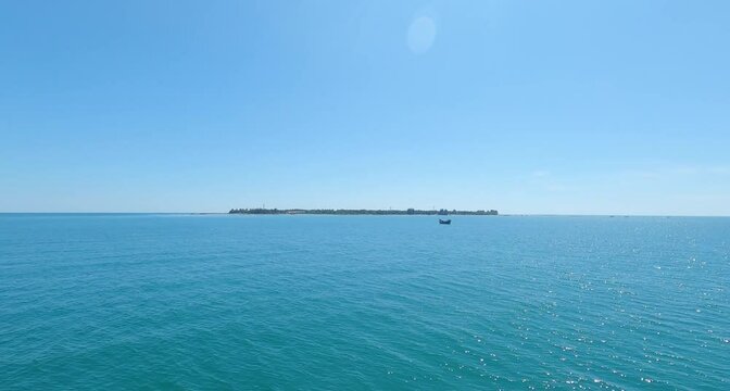 A small island in the middle of the blue sea