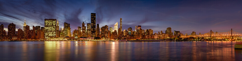 Manhattan Midtown East skyscrapers from the East River at twilight. The panoramic New York City...