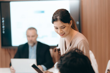 Diverse international executive business partners group discuss report at boardroom meeting table. Multiracial team negotiating project developing business strategy doing paperwork analysis in office.