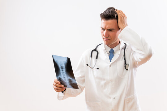 Image of worried  doctor looking at  x-ray image .