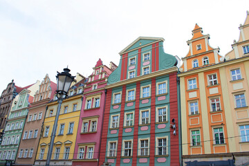 Fototapeta premium City view of the old buildings with colorful walls, decorative elements on the facades and lantern. Central square, old market with historical buildings. Old town. Poland, Wroclaw, January 2023
