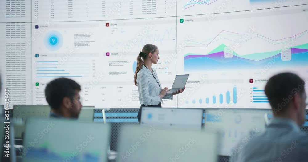 Poster Female Data Scientist Using Laptop And Analyzing Information And Graphs On Big Digital Screen In Monitoring Office. Caucasian Woman Working For Big Data Company, Diverse Employees Behind Computers.