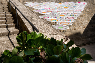 Crochet awning with drawings of mandalas in circles forming a triangle, manual work with aerial installation  in a rural town of Huesca, Coscojuela de Fantova, Europe. Charming micro towns