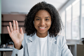 Web cam view of smiling African American businesswoman, business woman waving hand making video...