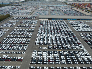 Aerial view of new cars stock at factory parking lot. Above view cars parked in a row. Automotive...