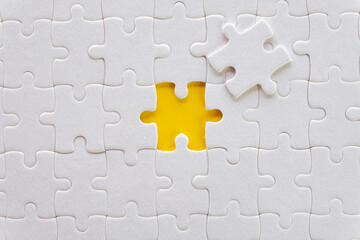 The last piece of missing jigsaw puzzle over yellow background use for mission,success,goal,target idea.