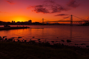 Hercilio luz cable bridge with sunset sky and reflection on water in Florianopolis, Brazil