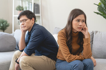 Family problem concept, Asian wife and husband sitting back to back in the living room at home have...