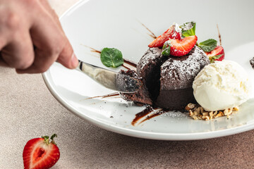 Chocolate fondant lava cake with strawberries, traditional french chocolate cake with liquid filling