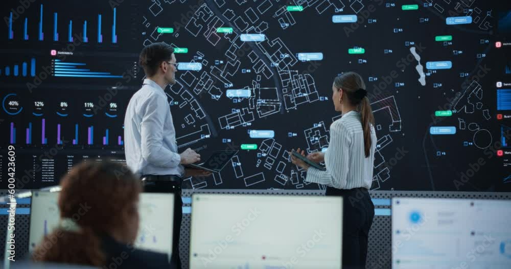 Poster male and female logistics specialists discussing new routs of delivery in front of big digital scree
