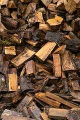 Wooden natural cut logs different sizes stored for fuel in countryside. Textured background.