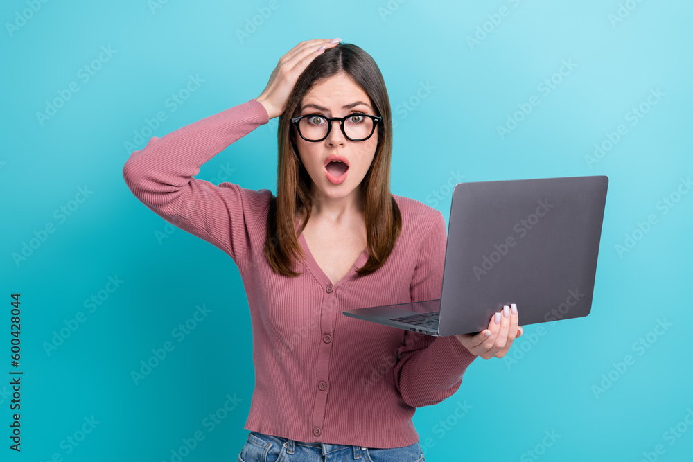 Sticker Portrait of confused speechless woman with stylish hairstyle wear pink shirt arms on head hold laptop isolated on blue color background