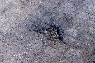 a damaged paved road with a lot of holes