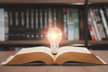 Light bulb and opened vintage book style vintage dark background,The idea and creativity of reading...