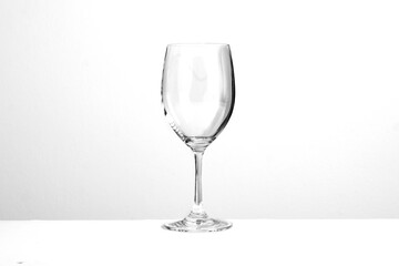 Close up empty red wine glass with the glass against gray background. Celebration party restaurant menu with copy space for text.