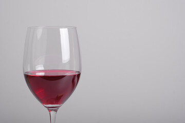 Close up red wine with the glass against gray background. Celebration party restaurant menu with copy space for text.