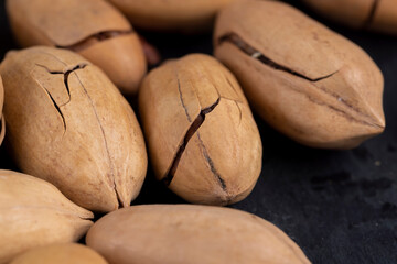 cracked unpeeled pecans close-up on the table