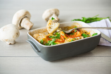 cauliflower baked with chicken fillet and mushrooms under cheese in a ceramic form