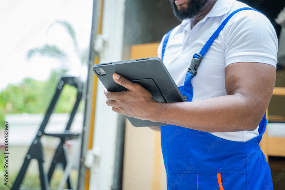 Poster delivery man checking list on clipboard near car before sending them to the homeowner.