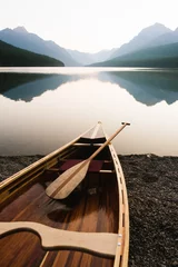 Fotobehang Wood canoe on the edge of Bowman Lake at sunrise in Glacier National Park, Montana © HANNAH
