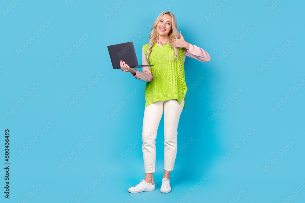 Poster Full size portrait of lovely attractive girl hold netbook demonstrate thumb up approval rate isolated on blue color background