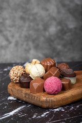 Praline Chocolate. Assorted truffles or praline chocolates on wood serving board