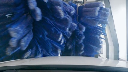 Modern car wash service cleaning car on automatic line, pov view, slow motion