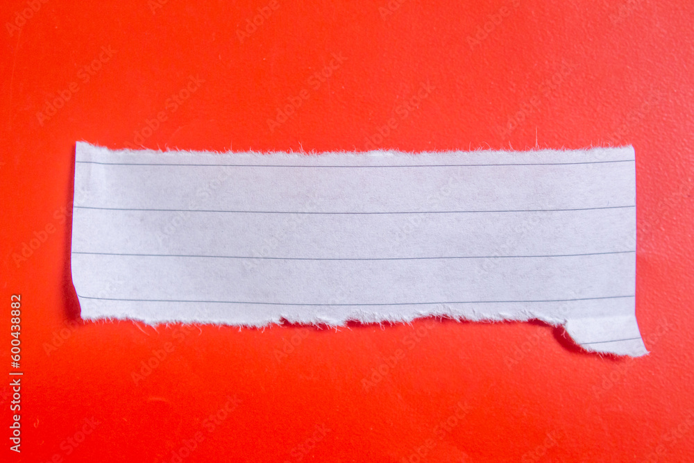Poster ripped lined notebook paper on red background with copy space.