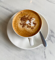 Hot latte with chocolate  in a cup at table
