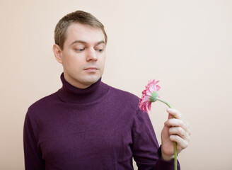 Young man hold gerbera flower in hand. - 600440602