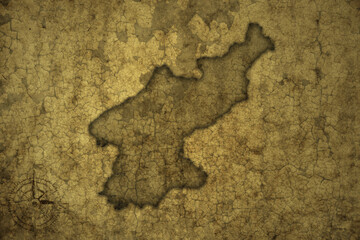 map of north korea on a old vintage crack paper background .