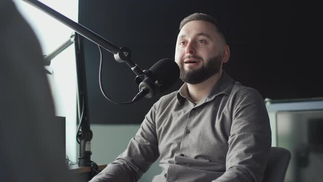 Two podcasters laughing and having fun in the studio. Two happy young people are doing a live audio broadcast together.