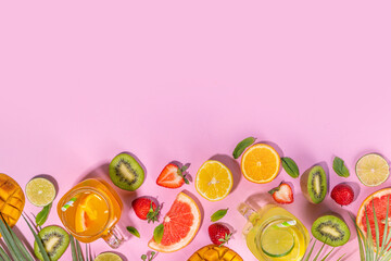 Set of summer cold lemonade mocktails, with fresh fruits and citrus, tropical leaves and flowers, top view on pink background