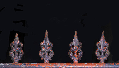 Painted iron gate finials in a row on black background
