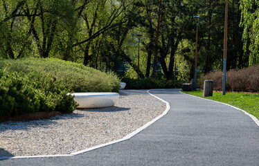 A winding asphalt pedestrian path in the park on a spring day.