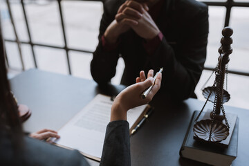 Young businessman concentrating on signing a contract with a skilled female lawyer and financial...