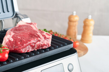 Raw prime steaks on electric grill. Black angus prime meat steaks Ribeye on modern electric grill...