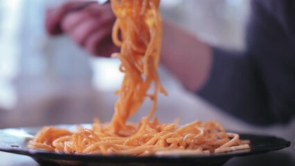 Savoring Italian Delight: Close-Up of Woman Enjoying Pasta with a Fork