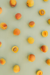 Flat lay composition with ripe peaches on neutral green background