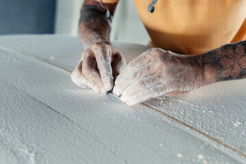 Crop man making stringer in surfboard