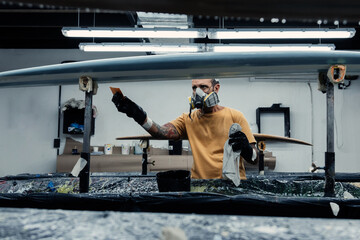 Focused man attaching film with scraper