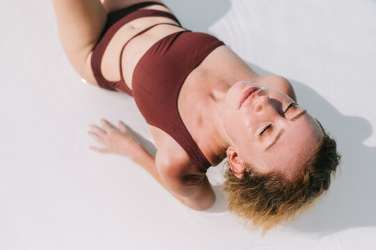Young woman in swimsuit lying on floor