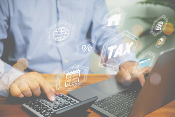 Businessman use a calculator calculate revenue for refund value tax and using laptop calculate cost and profit online for investment real estate . Investment, financial, and business concept.
