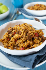 Pasta dish with ground beef, tomatoes, bell peppers, onions and herbs on a plate